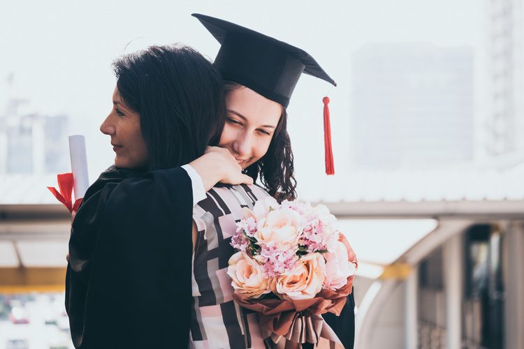 Women hugging graduation